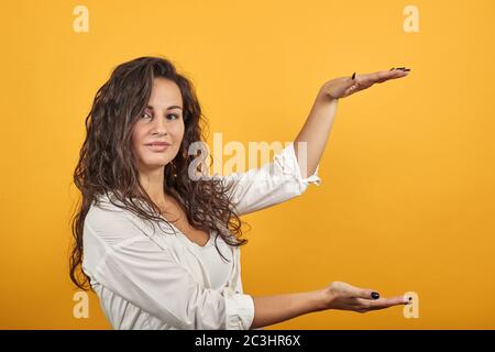 Formt mit zwei Händen ein großes Objekt, schnappt nach Überraschung und hält die Palmen vor sich Stockfoto