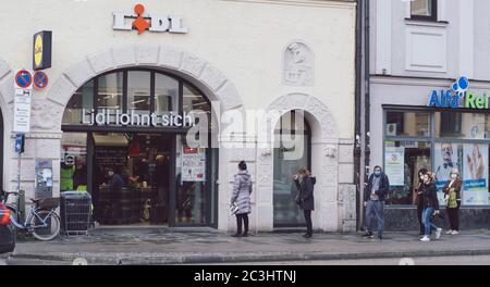 MÜNCHEN, 02. Mai 2020: In München stehen die Leute vor einem Lebensmittelgeschäft. Schutz vor Coronavirus durch Gesichtsmasken und SA Stockfoto