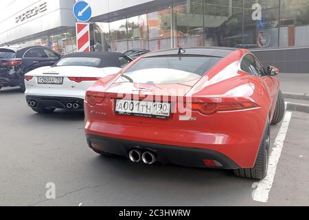 Moskau. Herbst 2018. Rot und Weiß Autos. Zwei Jaguar F - Typ S in der Nähe des Porsche-Händlerbetriebs. Stockfoto