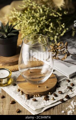 Vertikale Hochwinkelaufnahme eines leeren Glases auf einem Wunderschön dekorierter Holztisch Stockfoto