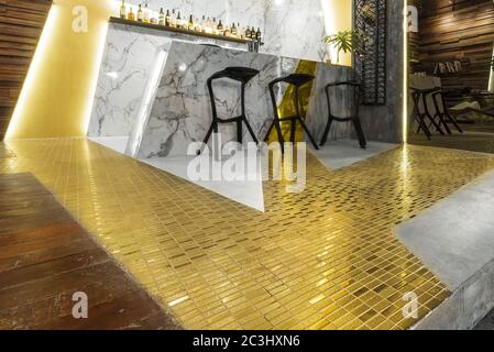 Low-Angle-Schuss auf eine Bar Zähler auf dem Boden Dekoriert mit goldenen und weißen Fliesen Stockfoto