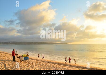 Jimbaran ist ein Fischerdorf und Küstenort südlich von Kuta auf der indonesischen Insel Bali. Leute, die am Strand spielen. Stockfoto