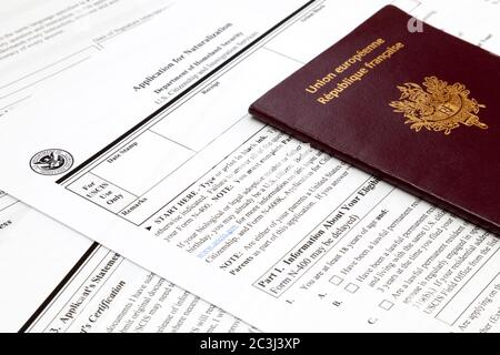 Ein französischer Pass auf dem oberen Teil eines amerikanischen Einbürgerungsantrags. Stockfoto