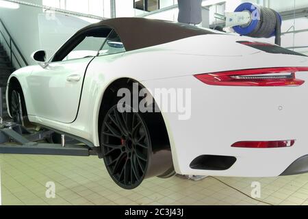 Moskau. Februar 2019. Weißes Porsche 911 Cabriolet am Lift im Service Center. Austausch der Räder. Reifenmontage. Schwarze, matte Custom-Räder Stockfoto