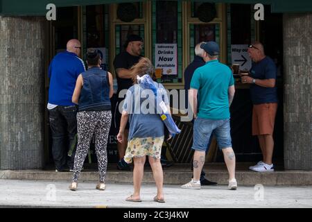 Cardiff, Wales, Großbritannien. Juni 2020. Leute vor einem Pub im Stadtzentrum von Cardiff, die Getränke zum Mitnehmen servieren. Kredit: Mark Hawkins/Alamy Live Nachrichten Stockfoto