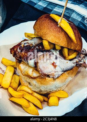 Vertikale High-Winkel-Aufnahme des Tellers köstlich Hähnchenburger mit Käse und Pommes frites Stockfoto