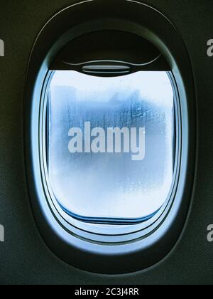 Vertikale Nahaufnahme eines Flugzeugfensters Stockfoto