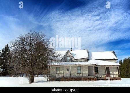 Verschneite, ruckige alte Wohnung in der Beauce Region von Quebec, Kanada. Bild von der öffentlichen Straße aufgenommen. Stockfoto