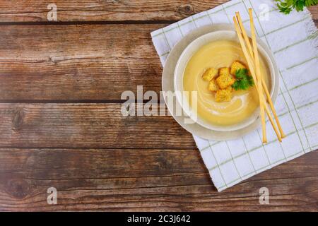 Frische hausgemachte cremige Hühnersuppe in einer grauen Schüssel, garniert mit knusprigen Croutons und italienischen Brotstäbchen. Stockfoto