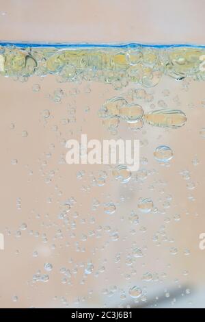 Öl bläht im Wasser mit beigem Hintergrund. Stockfoto