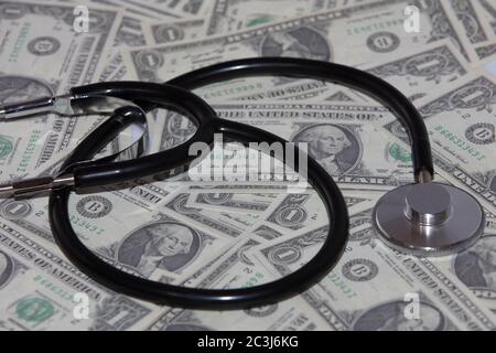 High-Angle-Aufnahme eines Stethoskops auf einem Stapel von 1 Dollar Stockfoto