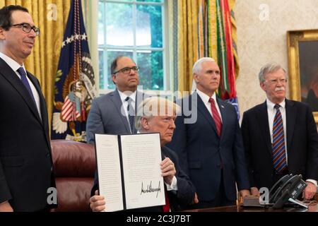 Washington, Vereinigte Staaten Von Amerika. Mai 2018. WASHINGTON, DC - WOCHE VOM 21. MAI: Präsident Donald J. Trump, mit Vizepräsident Mike Pence, rechts, US-Finanzminister Steven Mnuchin, links, Und der Nationale Sicherheitsberater John Bolton, rechts, im Oval Office im Weißen Haus, zeigt seinen unterzeichneten Executive Order, der zusätzliche Schritte unternimmt, um die Situation in Venezuela zu adressieren, Montag, 21. Mai 2018, in Washington, DC Menschen: Präsident Donald Trump Kredit: Storms Media Group/Alamy Live News Stockfoto