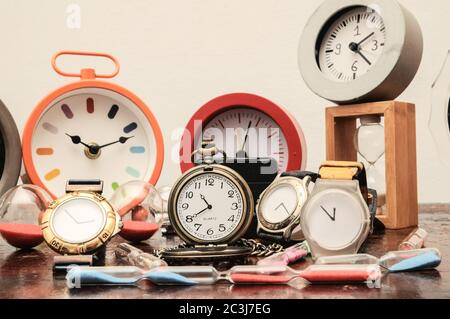 Viele verschiedene Uhren auf einem Woden Tisch Stockfoto