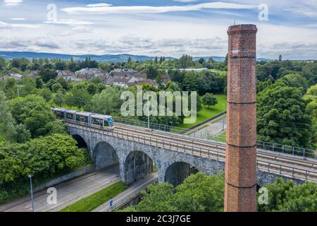 Luas Green Line Straßenbahn über das Viadukt Nine Arches Bridge über den Dodder Fluss in Milltown, Dublin. Stockfoto