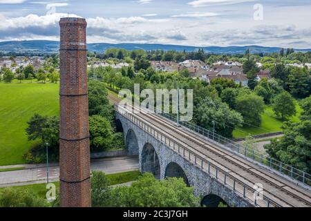 Luas Green Line Straßenbahn über das Viadukt Nine Arches Bridge über den Dodder Fluss in Milltown, Dublin. Stockfoto