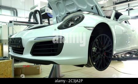 Moskau. Februar 2019. Weißes Porsche 911 Cabriolet am Lift im Service Center. Austausch der Räder. Reifenmontage. Schwarze, matte Custom-Räder Stockfoto