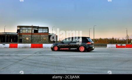 Sankt Petersburg. Winter 2018. Schwarzer volkswagen Golf mit pinken Felgen auf der Straße zwischen den Städten abgestimmt. Vor dem Hintergrund des Checkpoints, Sonnenuntergang und Staus. Stockfoto