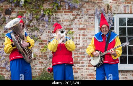 Downton, UK - 29 April 2017: Folk-Band als Gartengnomen verkleidet unterhalten die Massen auf der jährlichen Kuckuckmesse in Downton, Wiltshire, UK. Stockfoto