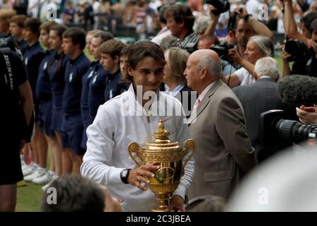 Rafael Nadal verlässt das Spielfeld mit seiner Trophäe, nachdem er Tomas Berdych besiegt hat, um das Finale der Männer im Einzel 2010 in Wimbledon zu gewinnen. Stockfoto