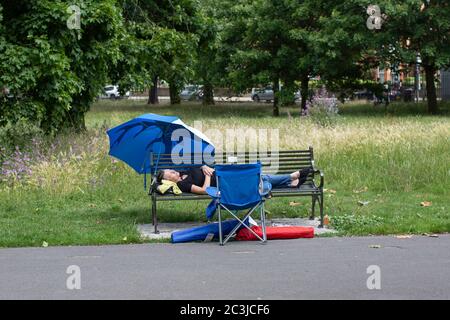 Brockwell Park, London, England. Juni 2020. Eine Frau, die auf einer Parkbank im Brockwell Park in der Nähe von Brixton und Herne Hill in Südlondon schläft, während die britische Regierung ab Montag, dem 15. Juni, die Sperrgesetze des Coronavirus erheblich lockert. (Foto von Sam Mellish / Alamy Live News) Stockfoto