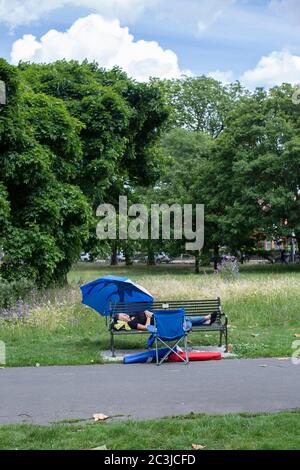 Brockwell Park, London, England. Juni 2020. Eine Frau, die auf einer Parkbank im Brockwell Park in der Nähe von Brixton und Herne Hill in Südlondon schläft, während die britische Regierung ab Montag, dem 15. Juni, die Sperrgesetze des Coronavirus erheblich lockert. (Foto von Sam Mellish / Alamy Live News) Stockfoto