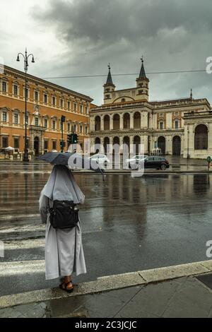 Eine Nonne überquert die Kreuzung mit der Ampel auf der Piazza San Giovanni in Laterano. Rom, Latium Region, Italien, Europa Stockfoto