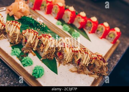 Großes Set von Sushi-Rollen warme Ebi Sake Unagi Frühling. Sortiment Philadelphia Rollgerichte aus japanischem rohem Fisch auf einem Teller in luxuriösen traditionellen Res Stockfoto