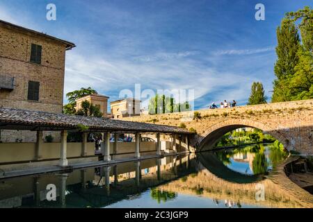 1. Juni 2019 - Bevagna, Umbrien, Italien. Das alte Waschhaus und die gemauerte Brücke über den Fluss, im mittelalterlichen Dorf. Blauer Himmel bei Sonnenuntergang. Baum Stockfoto