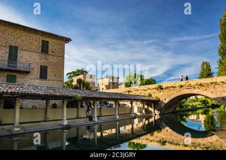 1. Juni 2019 - Bevagna, Perugia, Umbrien, Italien. Das alte Waschhaus und die gemauerte Brücke über den Fluss, im mittelalterlichen Dorf Bevagna. Blau Stockfoto