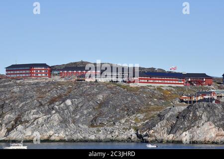 Das Hotel Arctic liegt stolz über den Felsen des Hafens von Ilulissat und bietet einen unvergleichlichen Blick auf die Disco Bay und die riesigen Eisberge, die vorbeisegeln. Stockfoto