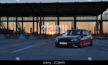 Sankt Petersburg. Winter 2018. Schwarzer volkswagen Golf mit pinken Felgen auf der Straße zwischen den Städten abgestimmt. Vor dem Hintergrund des Checkpoints, Sonnenuntergang und Staus. Stockfoto