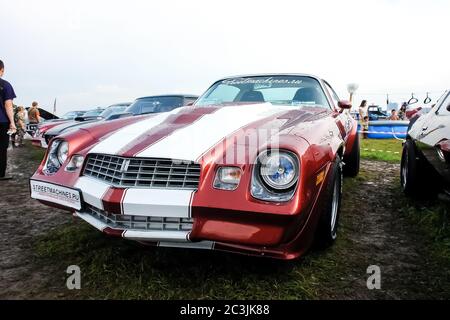 Moskau, Russland - 25. Mai 2019: Roter Chevrolet Camaro Z28 350 mit weißen Streifen auf der Motorhaube auf dem Feld geparkt Stockfoto