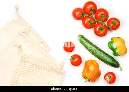 Kreatives Layout von Tomaten, Gurken, Paprika und Mesh-Baumwolle wiederverwendbare Taschen Stockfoto
