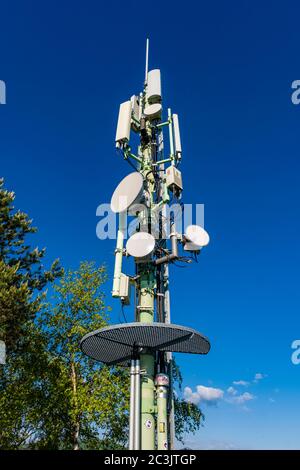 Ein Mobilfunk-Basisstation Mast mit Antennen und Reflektoren Stockfoto