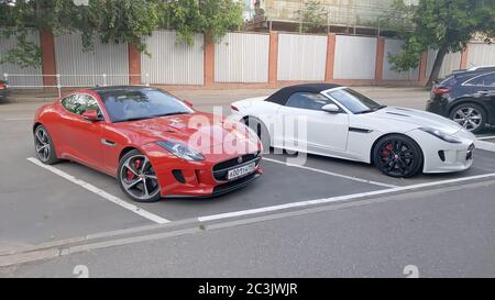Moskau. Herbst 2018. Rot und Weiß Autos. Zwei Jaguar F - Typ S in der Nähe des Porsche-Händlerbetriebs. Stockfoto
