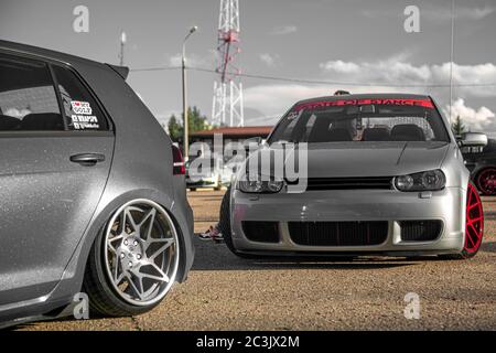 Moskau, Russland - 19. Juli 2019: Getuntes Low-Sport-Fließheck mit roten Candy-farbigen Leichtmetallfelgen. Volkswagen Golf mk 4 ist auf der Straße. Stanced Lowrider mit Badboy Kapuze Stockfoto