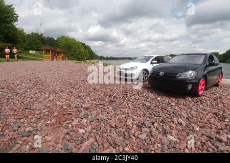 Moskau, Russland - 03. Mai 2019: Zwei Spielzeugautos Volkswagen Golf mk6 stehen auf einem Kiesstrand. Weiße und schwarze GTI stehen nebeneinander. Stockfoto