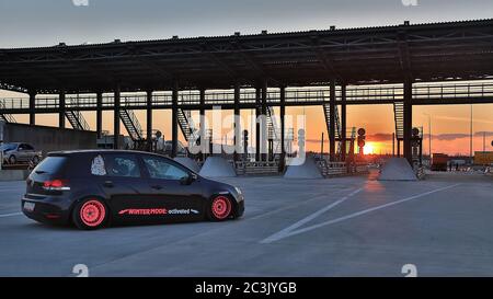 Sankt Petersburg. Winter 2018. Schwarzer volkswagen Golf mit pinken Felgen auf der Straße zwischen den Städten abgestimmt. Vor dem Hintergrund des Checkpoints, Sonnenuntergang und Staus. Stockfoto