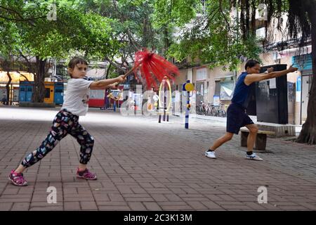 GUANGZHOU, CHINA - CA. MAI 2020: Ein kleines weißes Mädchen praktiziert Kung-Fu mit einer chinesischen Kampfkunstlehrerin, Stil Choy Li FUT in Kantonesisch. Stockfoto