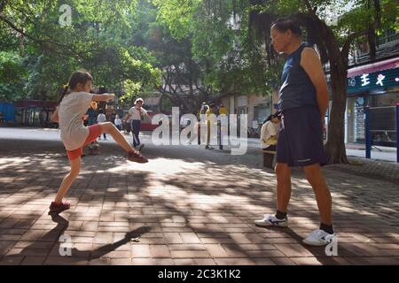 GUANGZHOU, CHINA - CA. MAI 2020: Ein kleines weißes Mädchen praktiziert Kung-Fu mit einer chinesischen Kampfkunstlehrerin, Stil Choy Li FUT in Kantonesisch. Stockfoto