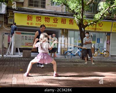 GUANGZHOU, CHINA - CA. MAI 2020: Ein kleines weißes Mädchen übt Kung-Fu mit einer chinesischen Kampfkunstlehrerin, Stil Choy Li FUT (Kantonesisch). Stockfoto