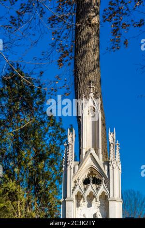 Vertikales Bild einer kleinen Marmorkirche gegen einen großen Baum auf dem Zentralfriedhof in Wien Stockfoto