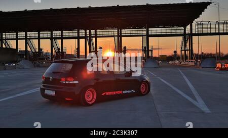 Sankt Petersburg. Winter 2018. Schwarzer volkswagen Golf mit pinken Felgen auf der Straße zwischen den Städten abgestimmt. Vor dem Hintergrund des Checkpoints, Sonnenuntergang und Staus. Stockfoto