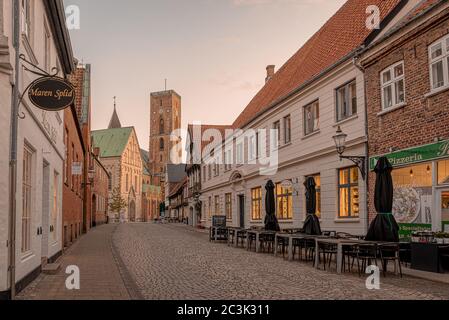 Der Turm der Ribe Kathedrale am Ende einer alten gepflasterten Straße im Sonnenuntergang, Ribe, Dänemark, 29. Mai 2020 Stockfoto