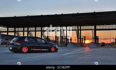 Sankt Petersburg. Winter 2018. Schwarzer volkswagen Golf mit pinken Felgen auf der Straße zwischen den Städten abgestimmt. Vor dem Hintergrund des Checkpoints, Sonnenuntergang und Staus. Stockfoto