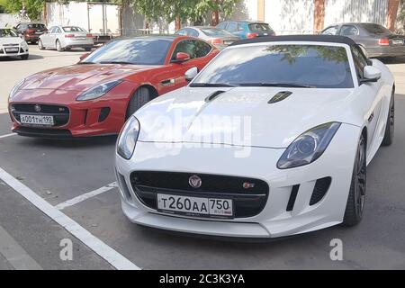 Moskau. Herbst 2018. Rot und Weiß Autos. Zwei Jaguar F-TYPE S in der Nähe des Porsche-Händlerbetriebs. Stockfoto