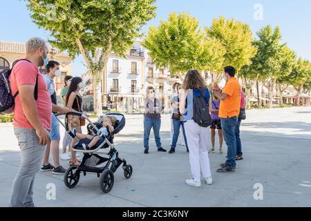 Baeza, Jaen, Spanien - 20. Juni 2020: Eine Gruppe von unbekannten Touristen mit einem professionellen Reiseführer Besuch der Altstadt von Baeza tragen schutzkleidung Stockfoto