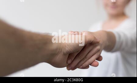 Nahaufnahme von Menschen, die sich unter den Lichtern eines die Hände schütteln Verschwommener Hintergrund Stockfoto