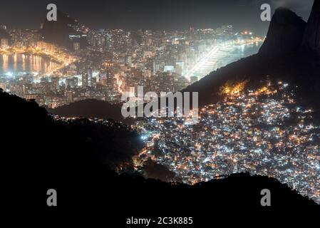 Nachtansicht oder Favela Rocinha im Berg und Ipanema Bezirk hinter in Rio de Janeiro, Brasilien. Stockfoto