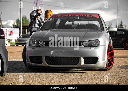 Moskau, Russland - 19. Juli 2019: Getuntes Low-Sport-Fließheck mit roten Candy-farbigen Leichtmetallfelgen. Volkswagen Golf mk 4 ist auf der Straße. Stanced Lowrider mit Badboy Kapuze Stockfoto